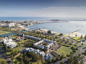 A coastal resort with multiple buildings, a marina, and a beach.
