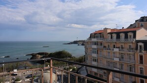 Un edificio costero con balcones, una estructura de cúpula y vista al mar.