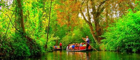 A river scene with boats, passengers, and a guide.