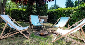 Two lounge chairs with a table and a fire pit in a garden setting. - Best Western Spreewald (Lübbenau/Spreewald)