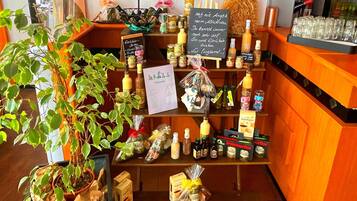 Exhibición de diversos alimentos y bebidas, que incluyen frascos, botellas y productos envasados, organizados en estantes.