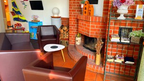 Una sala de estar acogedora con sofás de cuero, una chimenea y una estantería con libros y objetos decorativos.