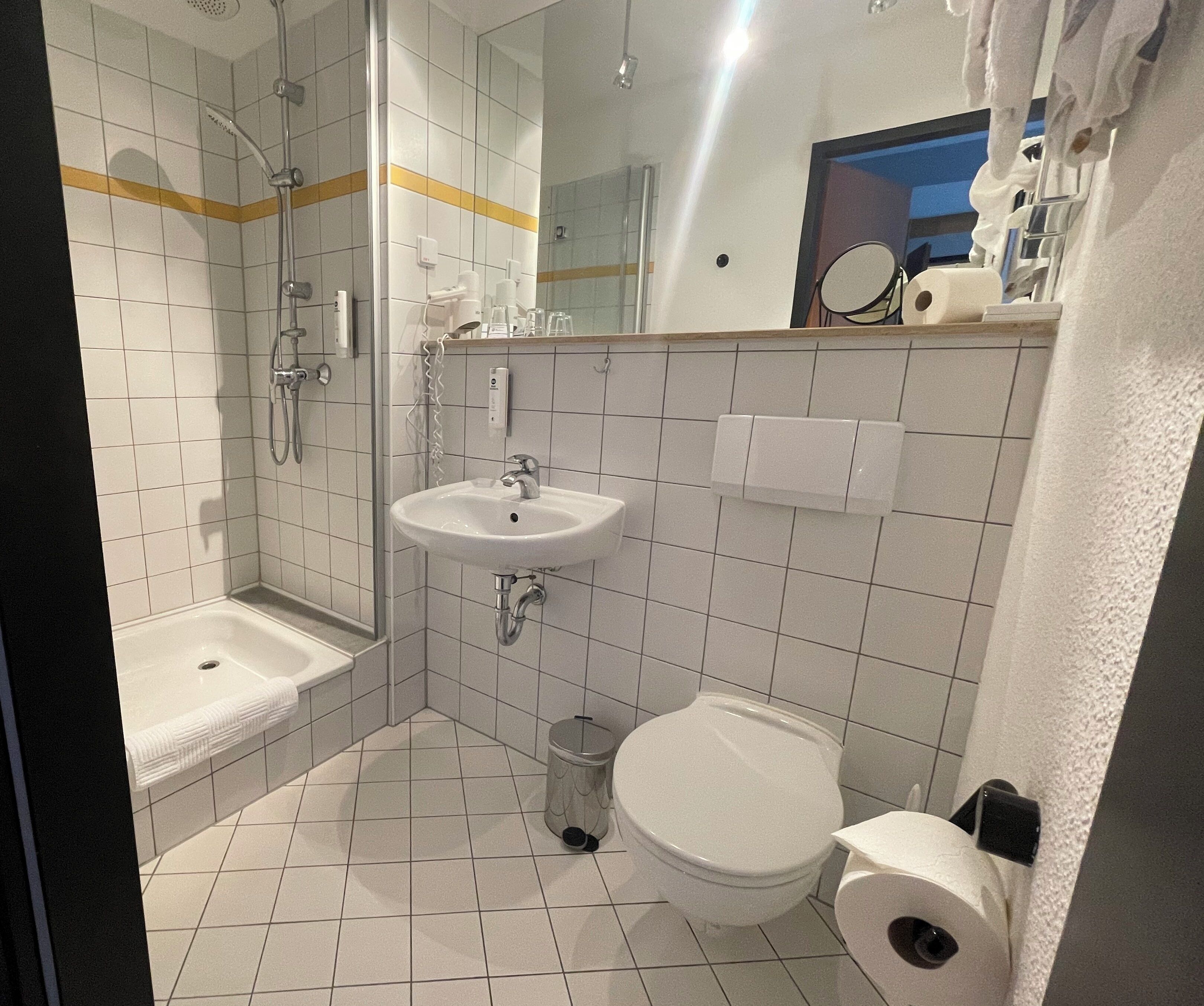 Een douche, een haardroger, pantoffels, handdoeken