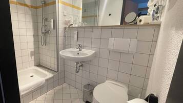 Een douche, een haardroger, pantoffels, handdoeken