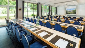 A conference room with multiple tables and chairs, large windows, and a projector screen. - Best Western Spreewald (Lübbenau/Spreewald)