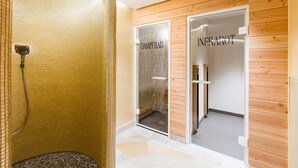 A modern bathroom with a glass shower enclosure, wooden panel walls, and a tiled floor. - Waldhaus Reinbek (Reinbek)
