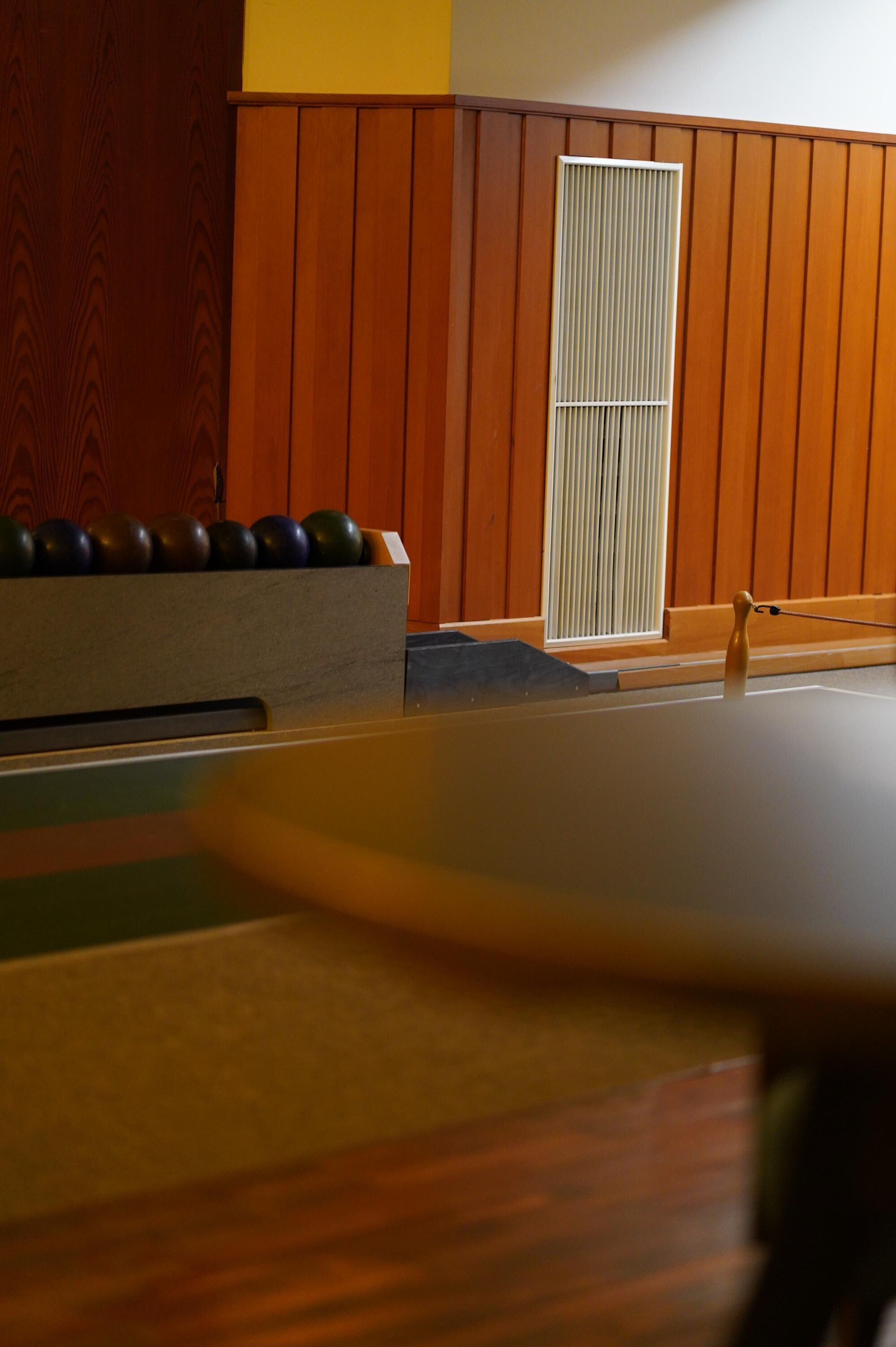 A billiards table with a wooden sideboard and a set of billiard balls.