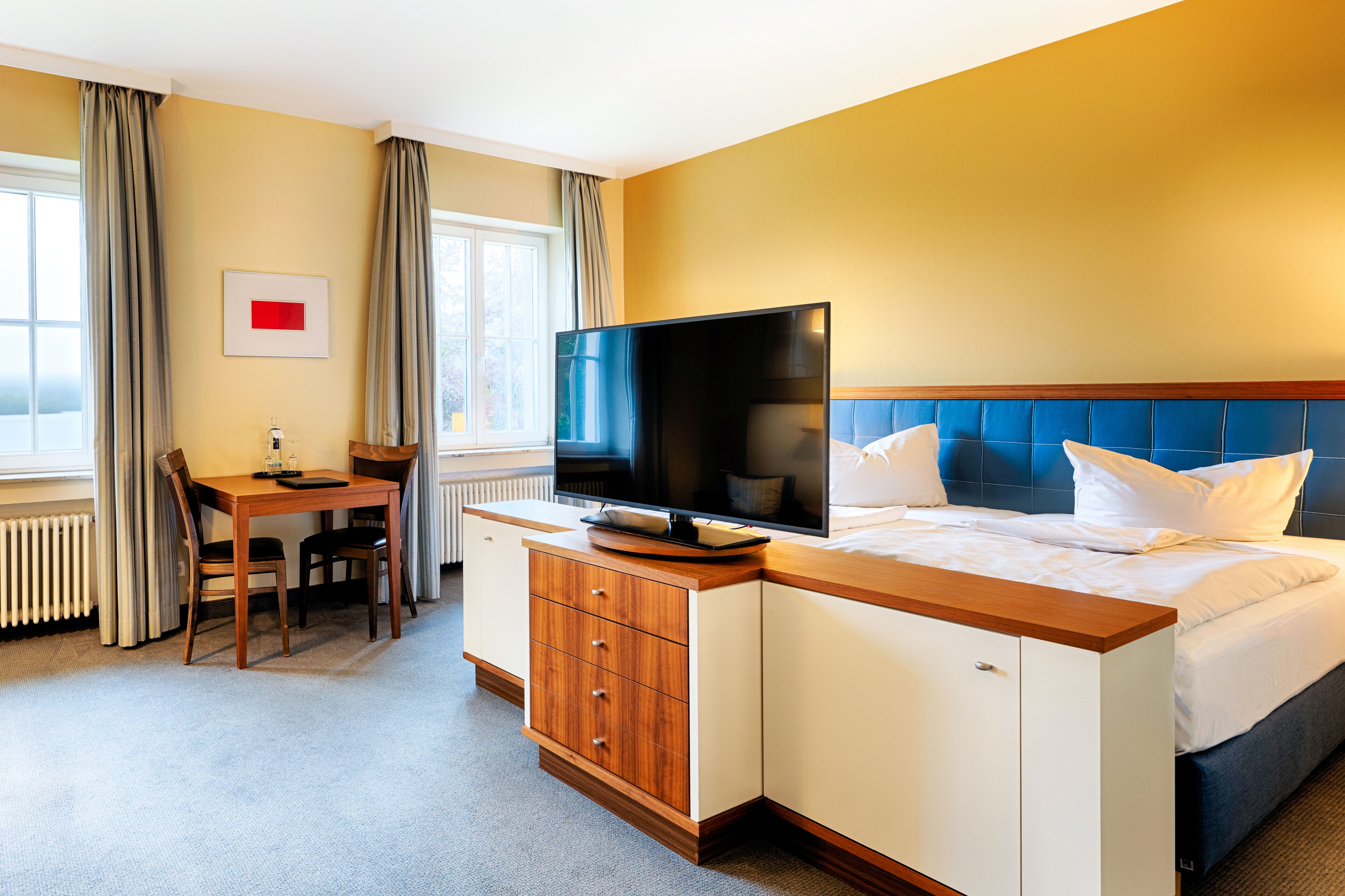 A hotel room with a bed, a television, a desk, and a chair.