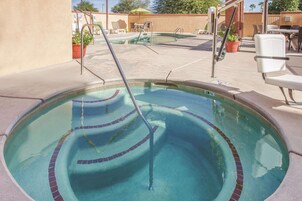 A swimming pool with a diving board and lounge chairs.