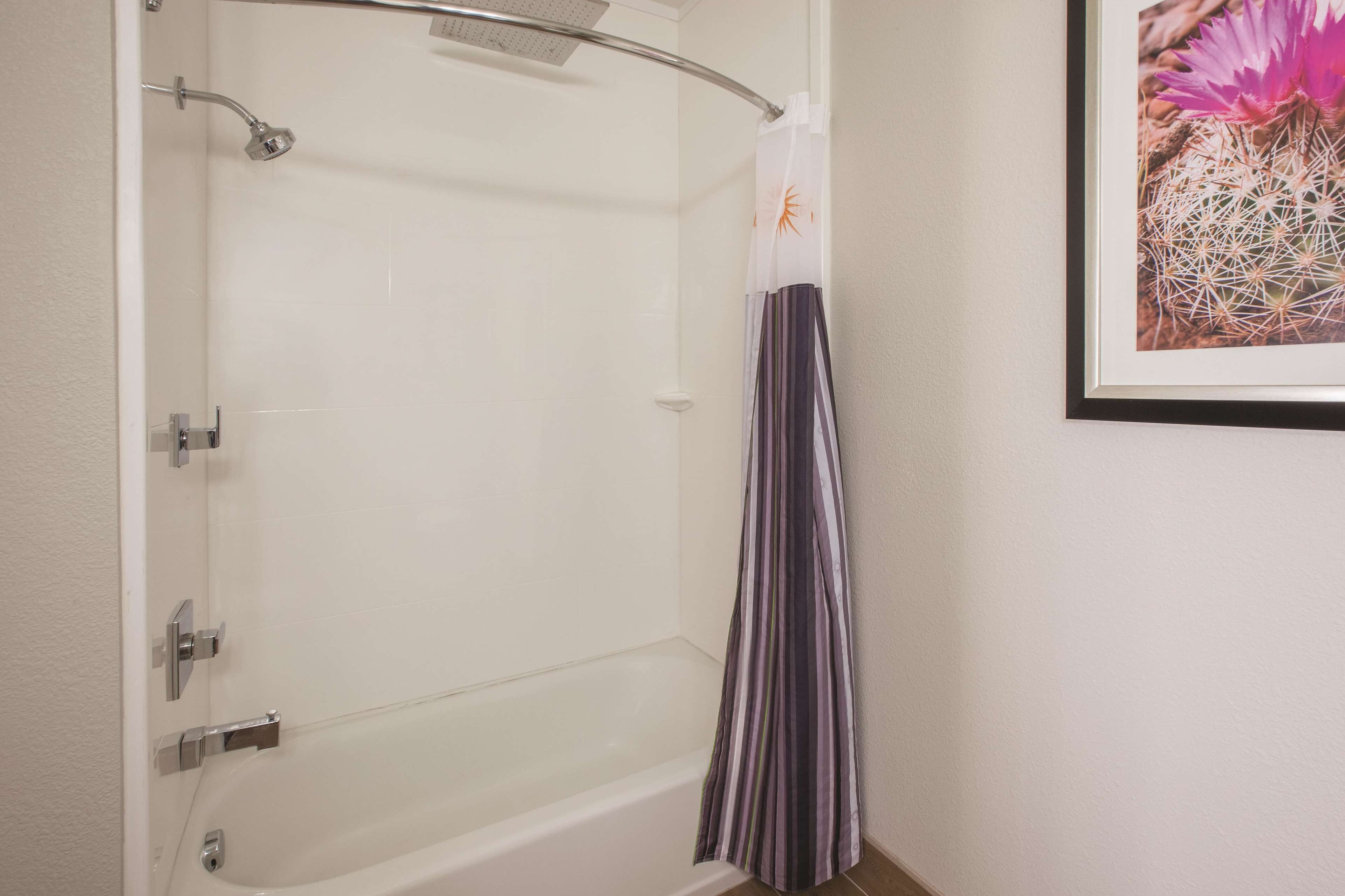 A bathroom with a bathtub, shower, and a curtain.