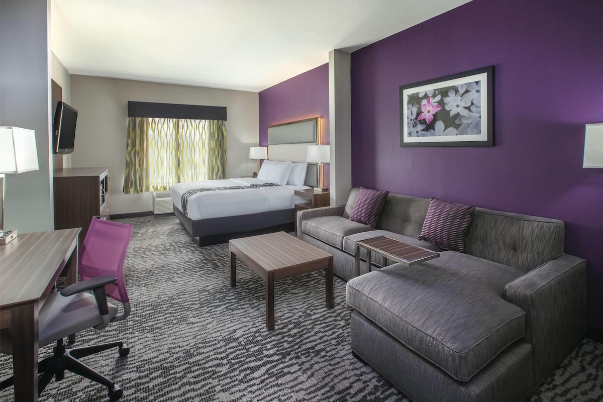 Une chambre d’hôtel avec un lit, un canapé, un bureau et une chaise.