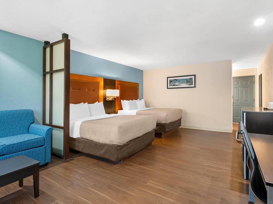 A hotel room with a bed, a sofa, a desk, and a television.