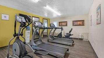 A hotel fitness room with treadmills, a stationary bike, and a water dispenser.