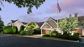 A residential building with a flagpole, well-maintained lawns, and a clear sky. - Residence Inn by Marriott Boston-Franklin (Franklin)