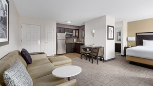 A hotel room with a sofa, a small round table, a bed, a kitchenette, and a dining area. - Residence Inn by Marriott Boston-Franklin (Franklin)