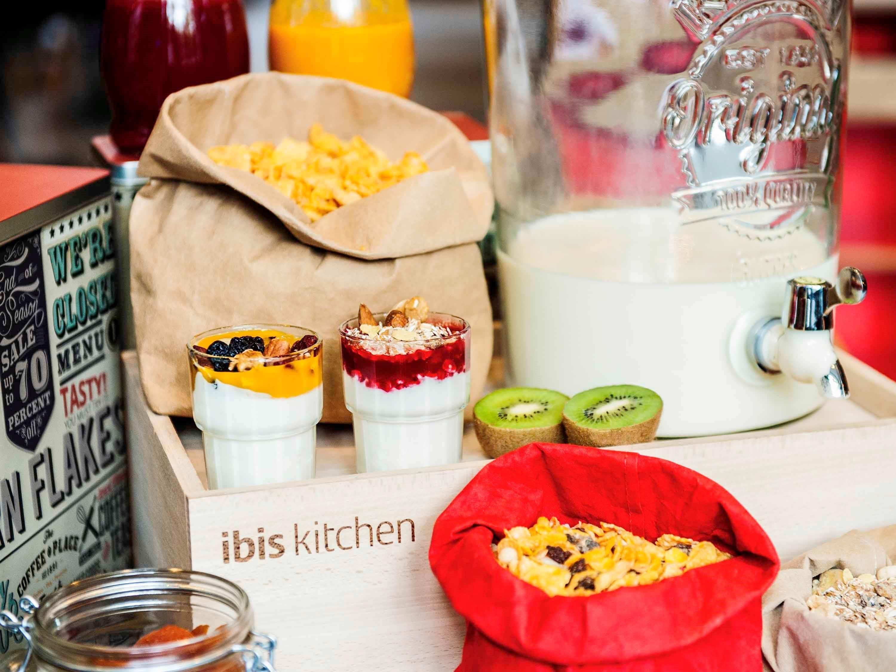 A kitchen counter with food items, a milk jug, and a sign reading "ibis kitchen".