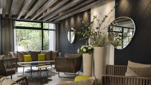A modern living room with a sofa set, a coffee table, and a large mirror. - Hôtel & Spa - Thalazur Arcachon (Arcachon)