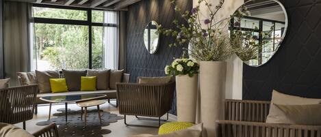 A modern living room with a sofa set, a coffee table, and a large mirror.