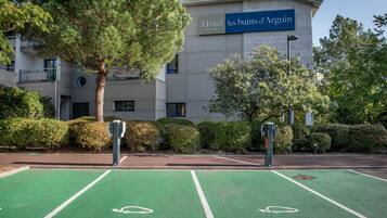 A hotel named "les bains d'Arguin" with a parking area and green bike lanes.