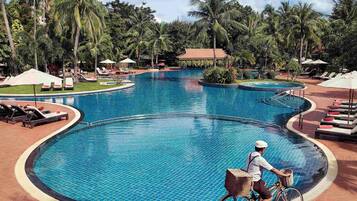 Una piscina al aire libre, camas de piscina gratis, sombrillas