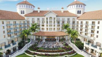 Un hotel con un patio central, varios balcones y una fachada simétrica.