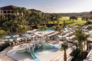 A resort with a pool area, lounge chairs, and a water slide.