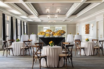 A hotel room with a sofa, a desk, a chair, and a view of palm trees through the balcony doors. at The Ritz-Carlton Naples, Tiburon