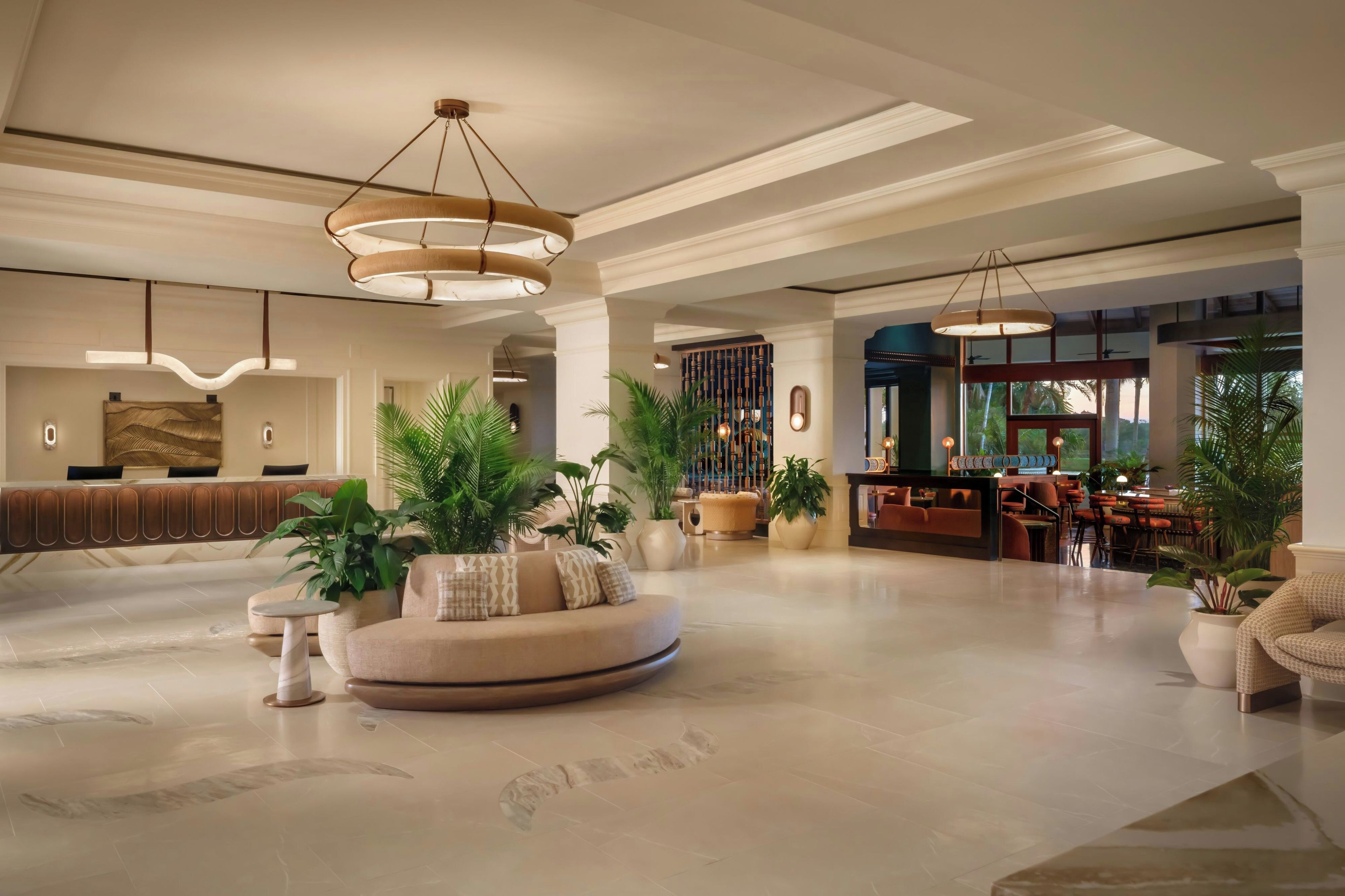 A spacious lobby with a reception desk, seating area, and a bar.