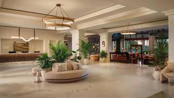 A spacious lobby with a reception desk, seating area, and a bar.