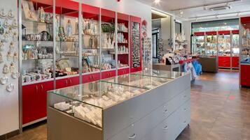 A jewelry store with glass display cases and red shelving units.