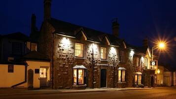 Un edificio de piedra con varias ventanas y un letrero que dice "The Arundell Arms Hotel".