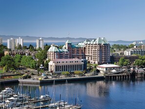 A waterfront hotel with a large building featuring a central dome and multiple wings, surrounded by a marina with several boats.