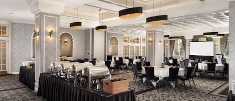 A conference room with tables, chairs, and a buffet setup.