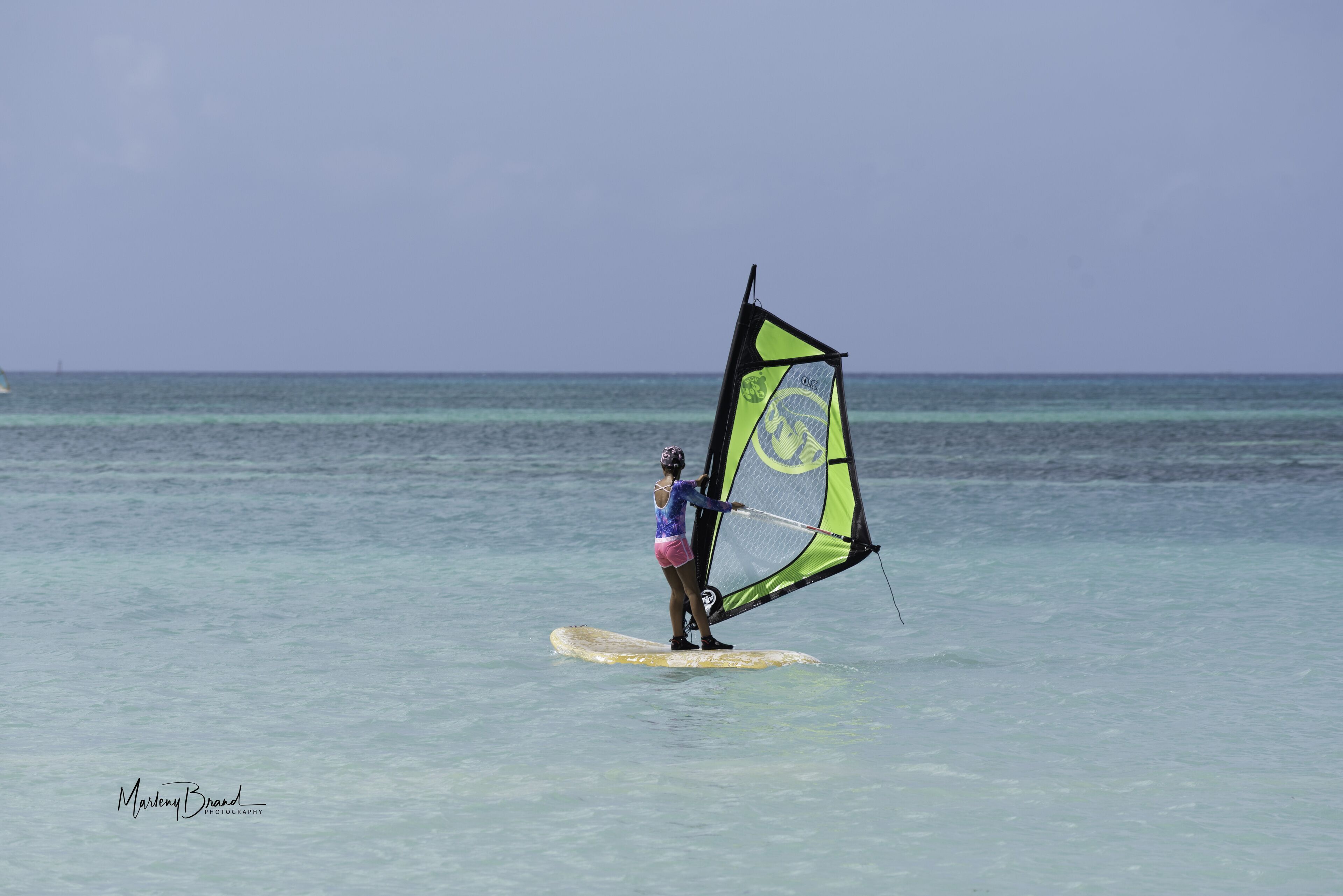 Uma pessoa praticando windsurf num dia claro.
