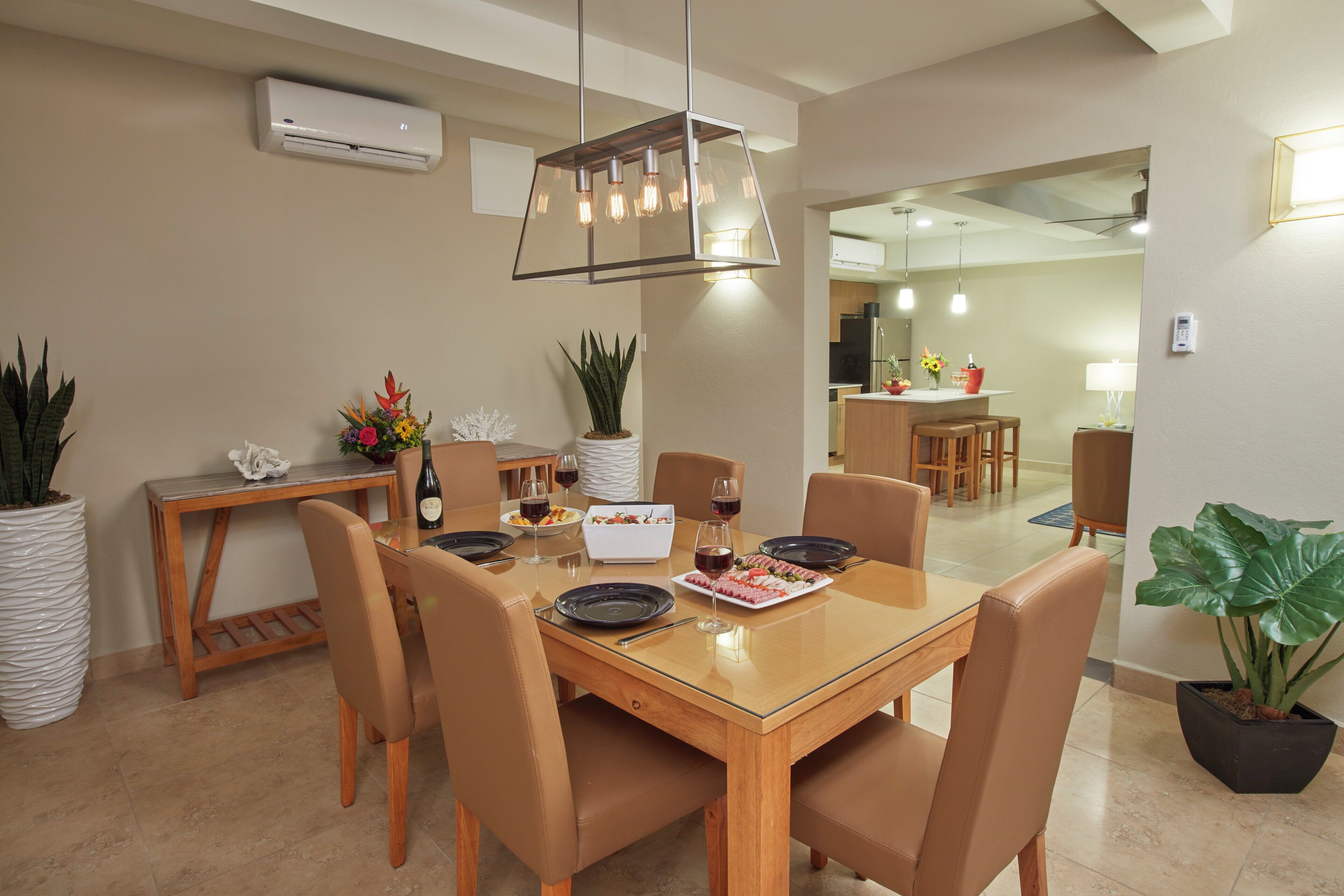 A dining area with a wooden table, chairs, and a modern pendant light.