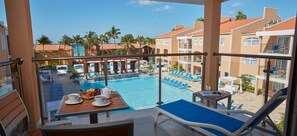 Relax by the resort pool, surrounded by lounge chairs and umbrellas.
