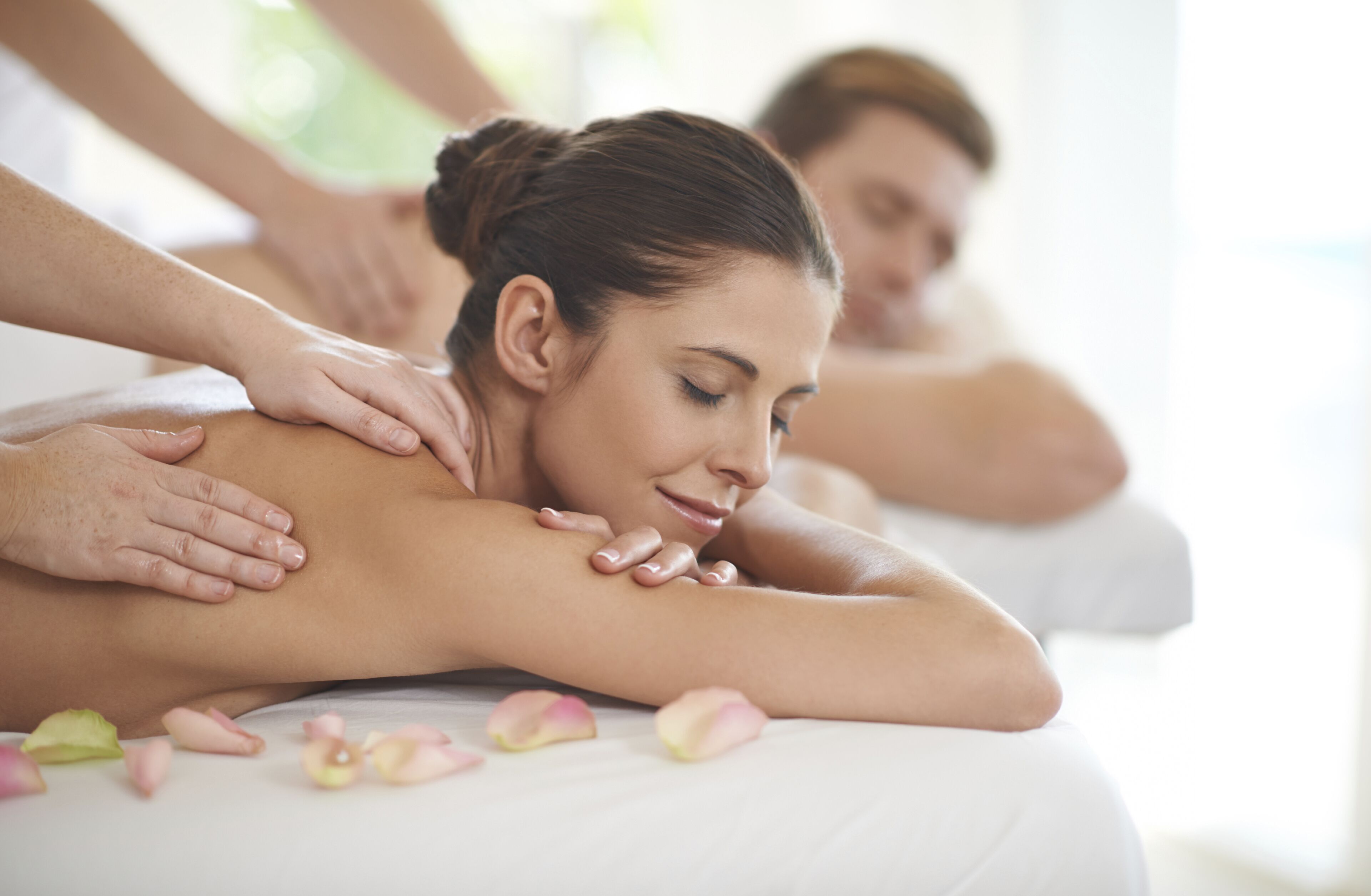 Une séance de massage où la personne est allongée sur le ventre sur une table de massage et reçoit un massage du dos.