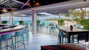 A seaside restaurant with outdoor seating, a bar area, and a view of the ocean. - Divi Dutch Village Beach Resort (Oranjestad)