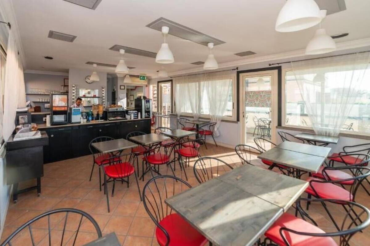 A restaurant with outdoor seating, a bar area, and large windows.
