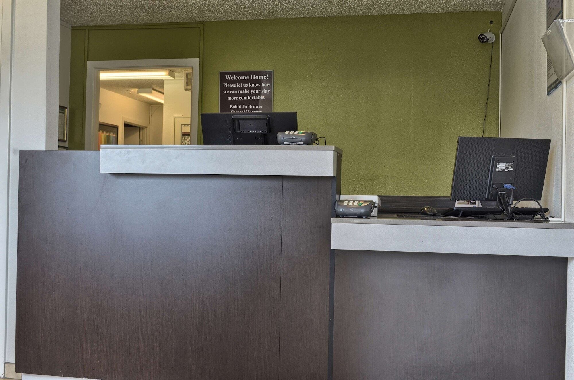 A reception desk with a sign that reads "Welcome Home! Please let us know how we can make your stay more comfortable."