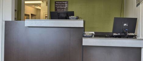 A reception desk with a sign that reads "Welcome Home! Please let us know how we can make your stay more comfortable."