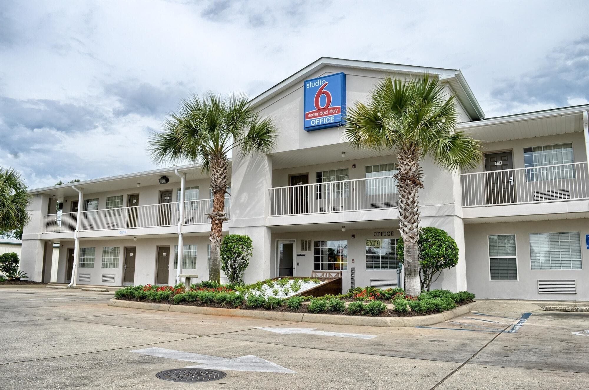 A two-story motel with a blue sign indicating it is a Studio 6 extended stay office.