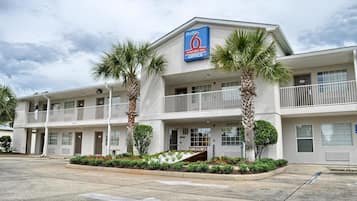 A two-story motel with a blue sign indicating it is a Studio 6 extended stay office.
