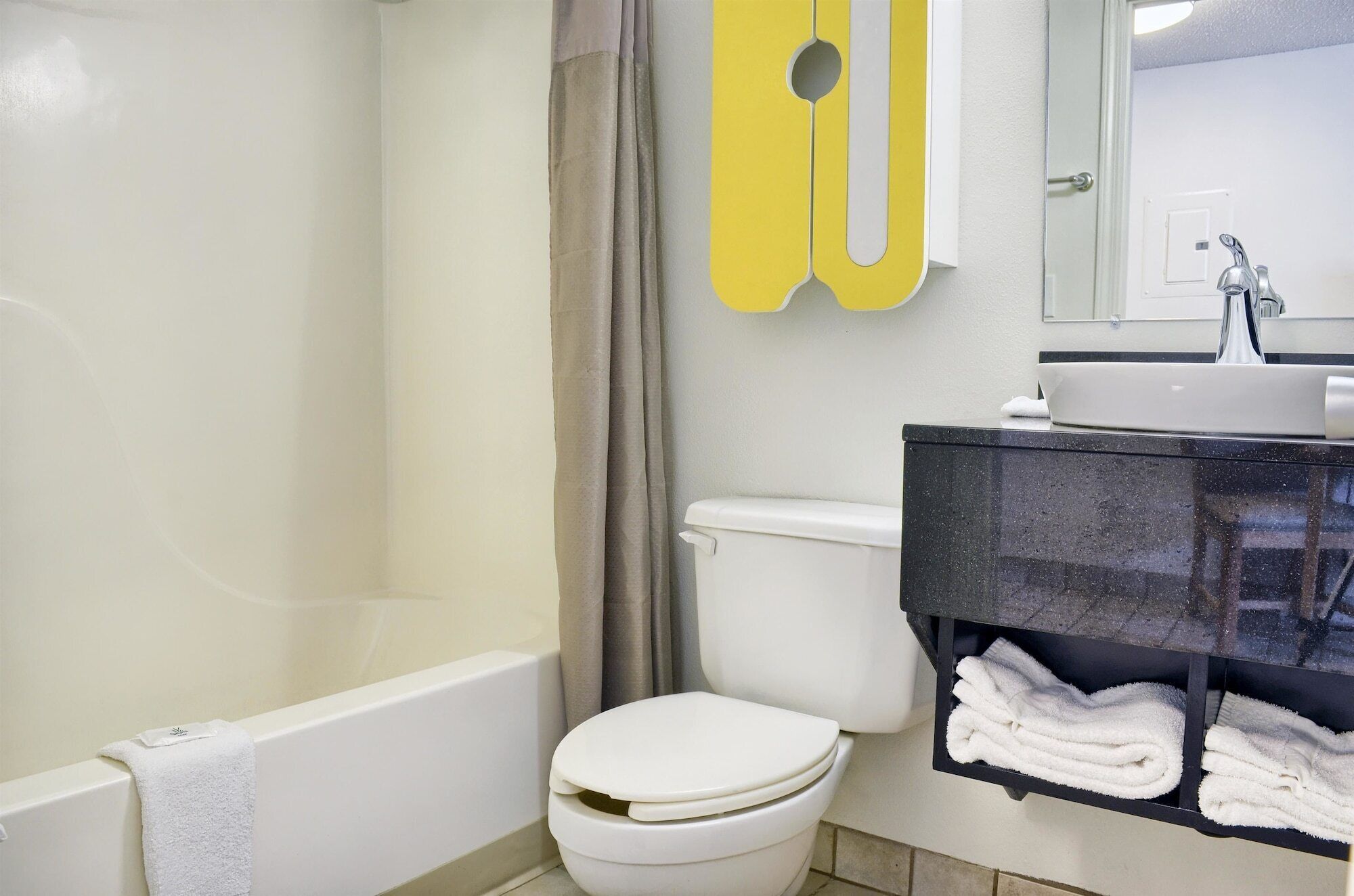 Ein Badezimmer mit Badewanne, Toilette und Waschbecken mit Handtuchhalter.
