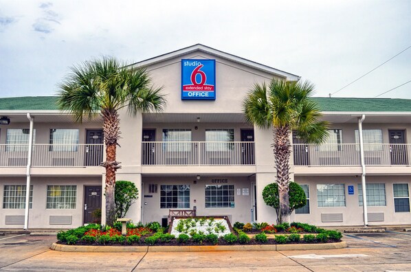 Studio 6 Extended Stay Office features a two-story facade with a central entrance and palm trees.