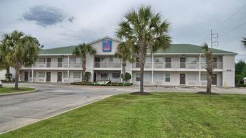 A two-story motel with a green roof and a blue sign indicating it has 6 rooms.