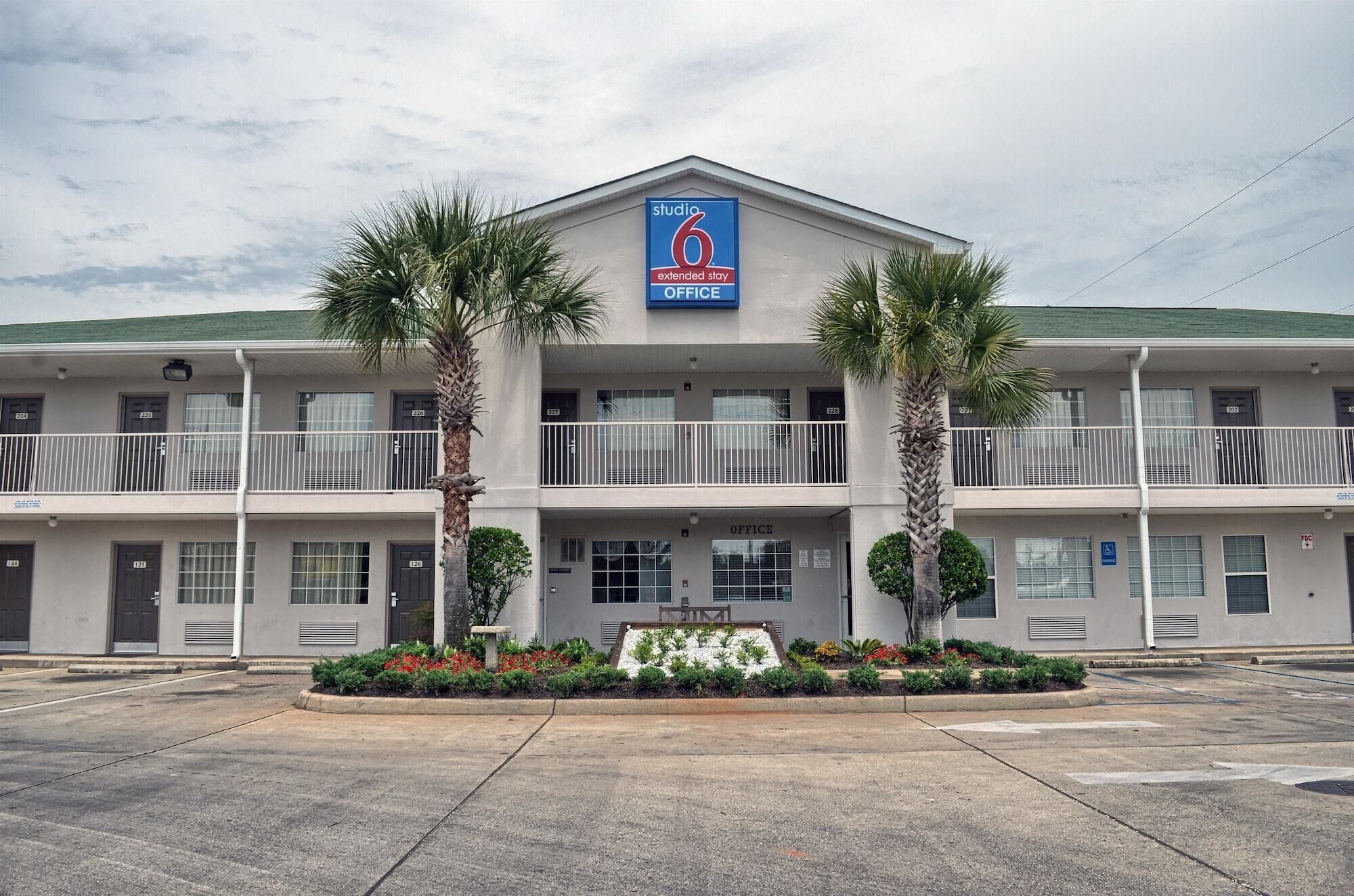 A two-story motel with a sign indicating 'Studio 6 Extended Stay Office'.