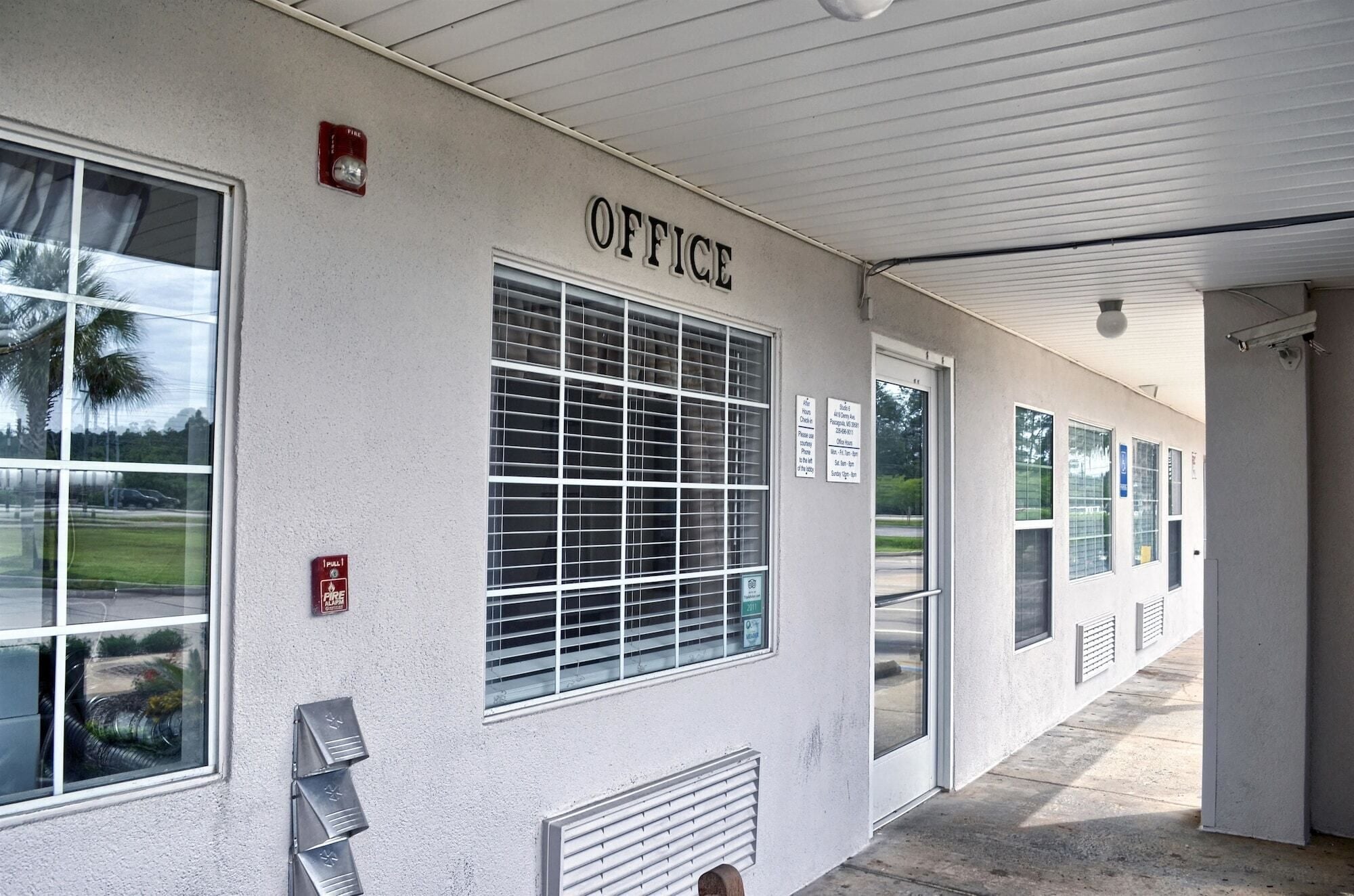 A building with a sign labeled "OFFICE" on the exterior wall.