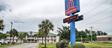 Een hotelschild met 'Studio 6 Extended Stay' en 'Alle kamers gloednieuw' erop.