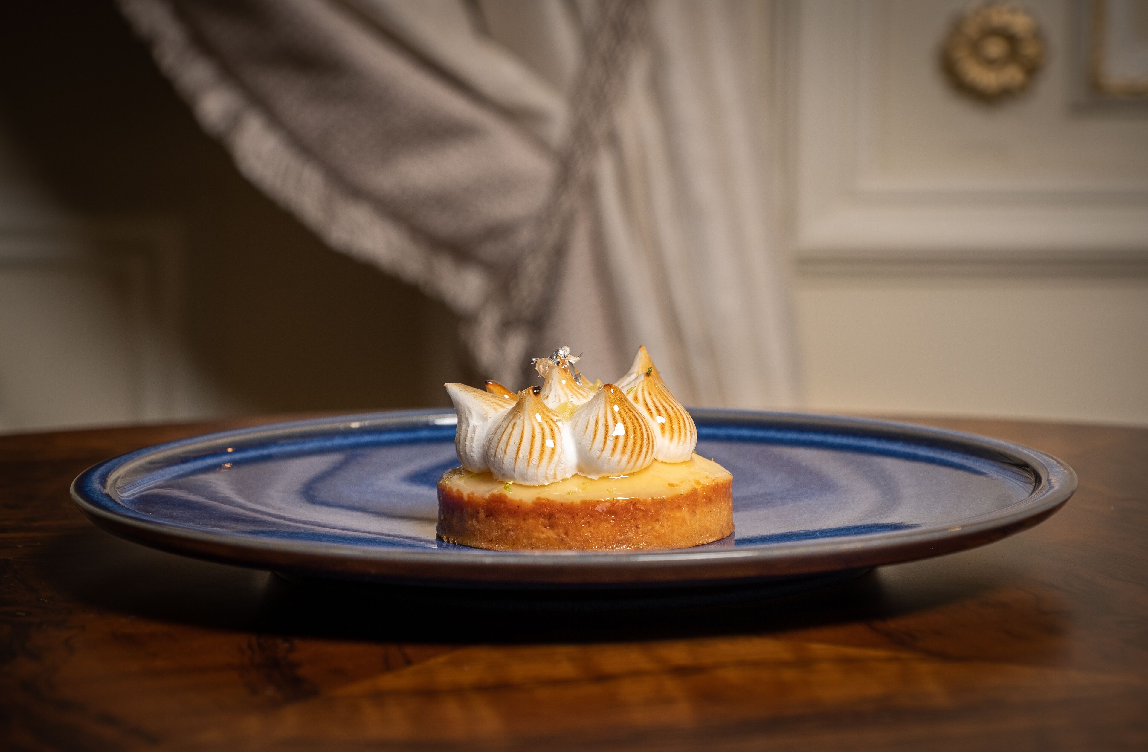 A dessert on a blue plate on a wooden table.